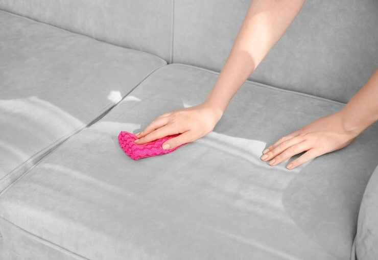 Pessoa limpando sofá de linho cinza