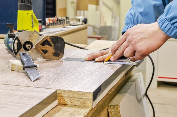 Pessoa realizando trabalhos manuais em uma placa de madeira MDF