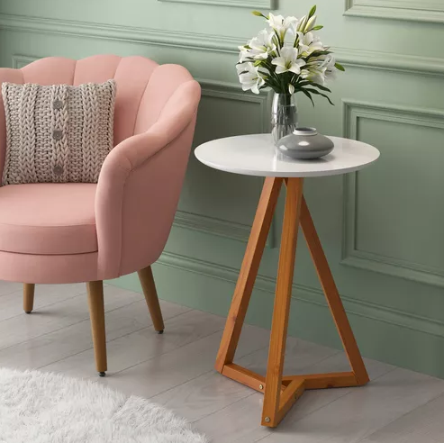 mesa lateral na cor branca ao lado de poltrona rosa