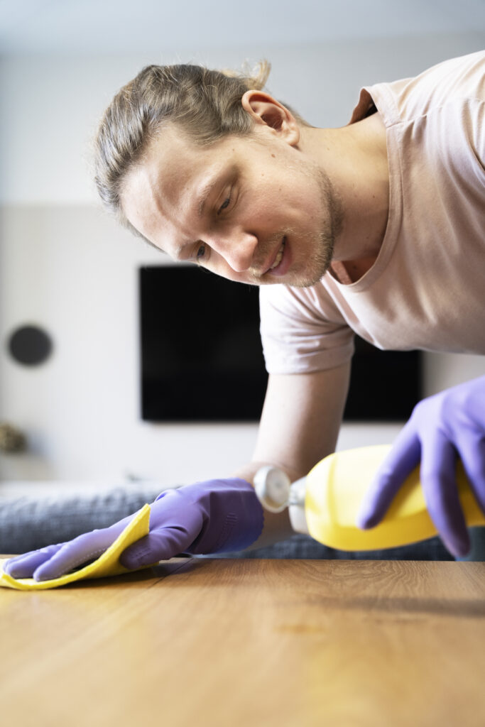 Homem usando produto de limpeza específico para móvel em MDF