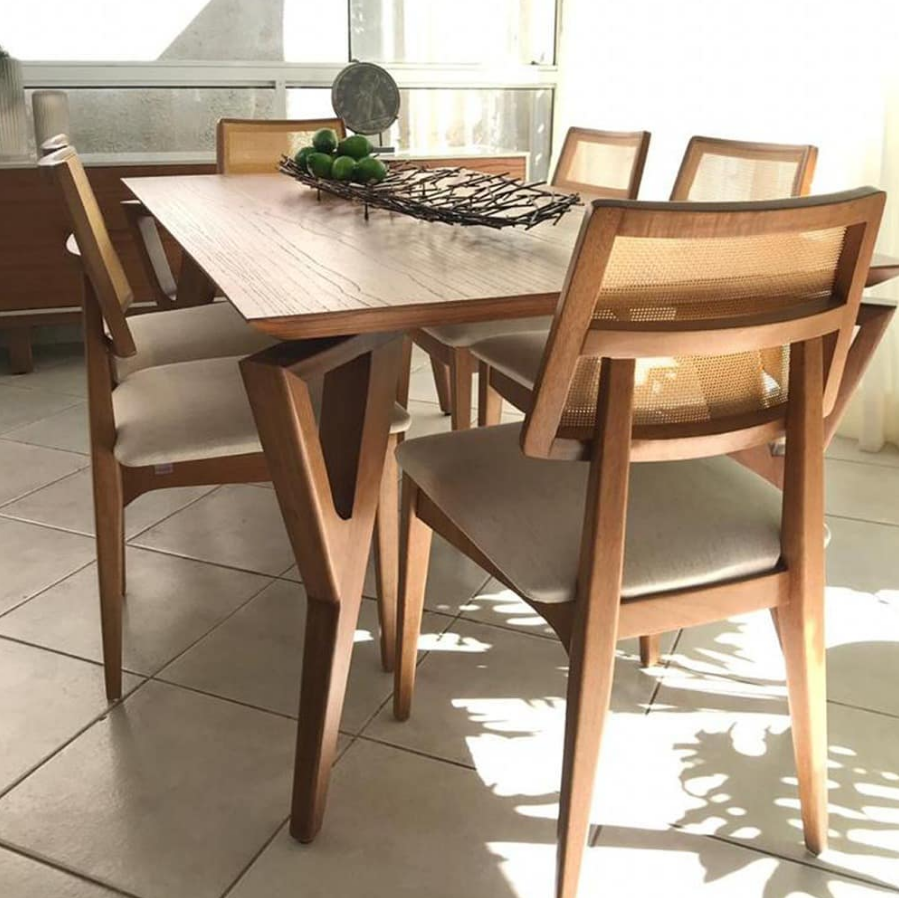 Mesa de jantar de madeira com cadeiras com encosto de palha indiana.