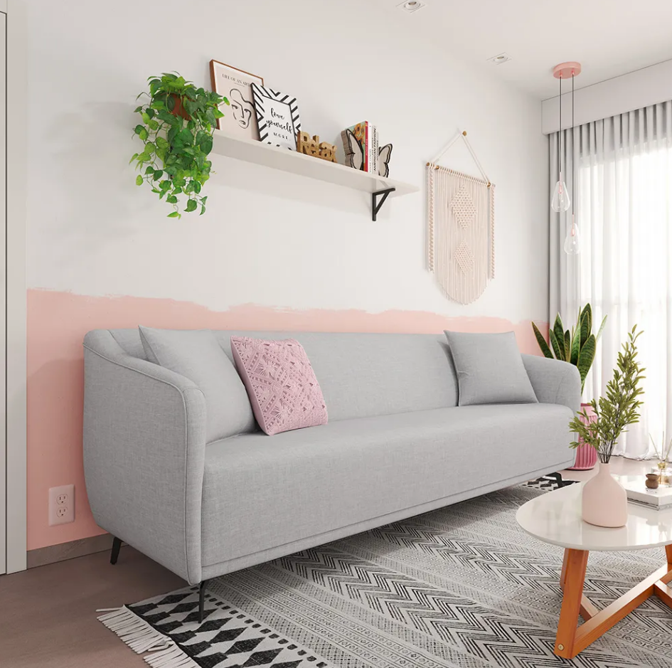 Ambiente com decoração boho e sofá cinzza claro com almofada rosa.