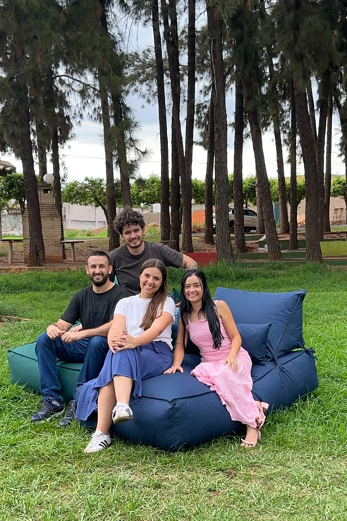 Quatro amigos reunidos em área externa.