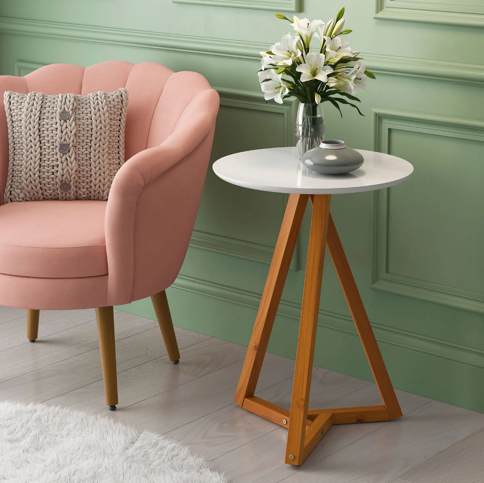 Mesa lateral Classic com tampo de mdf branco e pés de madeira na cor amêndoa ao lado de poltrona rosê e parede verde ao fundo.