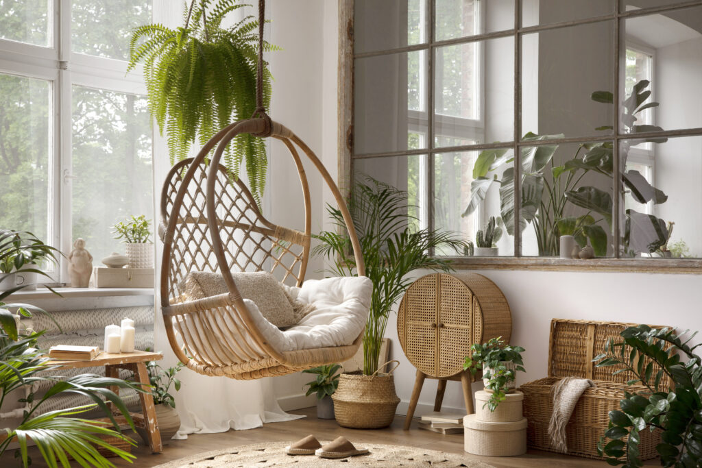 Decoração de estilo boho com vaso suspenso de samambaia e elementos de vime. Inspirada na biofilia.