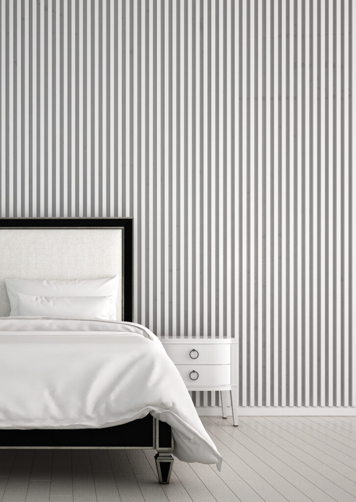 Quarto com papel de parede de listras verticais finas de coores neutras.