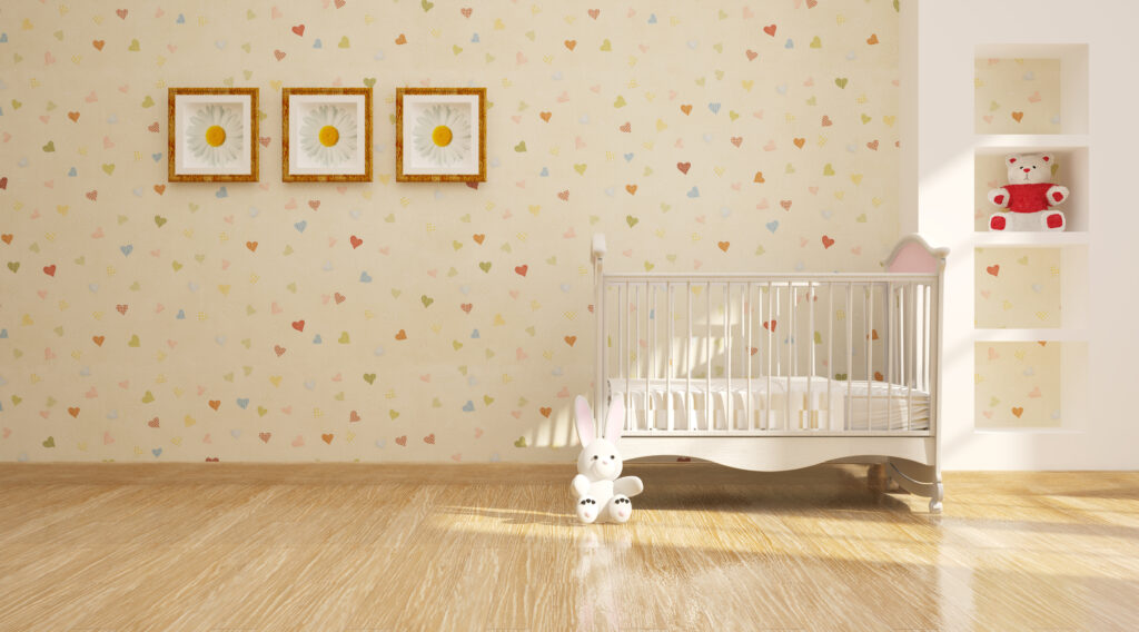 Quarto infantil com papel de parede estampado de corações coloridos.
