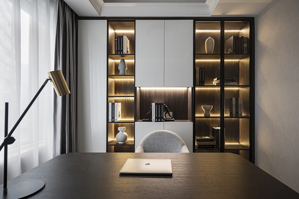 Escritório decorado com estante de marcenaria e led.