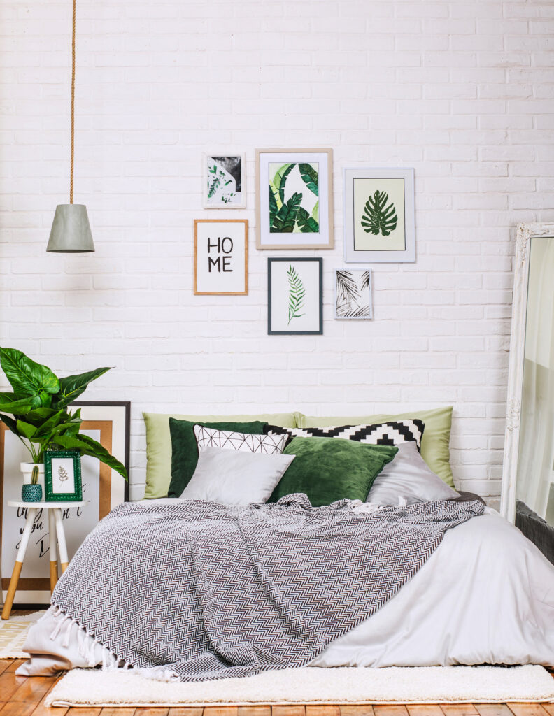 Quarto de hóspedes com decoração em branco, cinza e tons de verde.