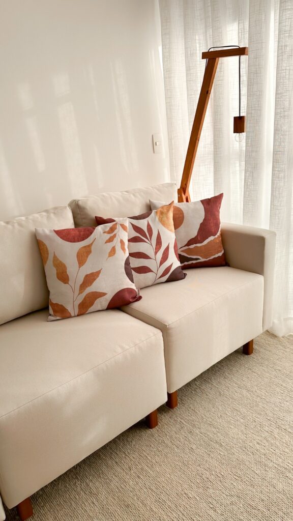 minimalismo quente com texturas em tecido off-white e almofada em cores outonais